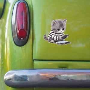 Cartoon grey cat sticker on green car surface near a vintage red tail light