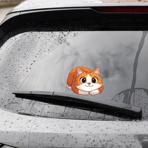 Cute cartoon orange fat cat car window sticker applied to rear glass with raindrops