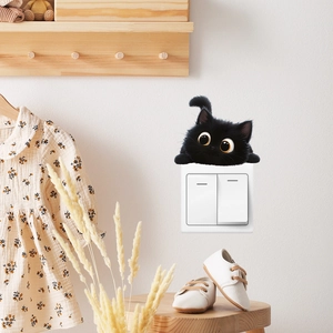 Detailed close-up of cartoon black cat wall sticker peeping over a white light switch