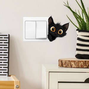 Close-up of a cartoon black cat wall sticker peeking over a light switch on a white wall