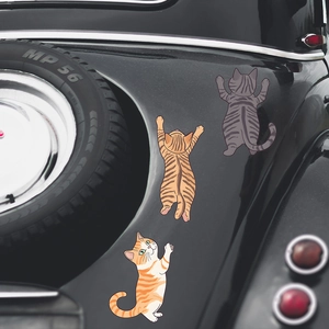 Three playful cartoon cat car stickers in orange, brown and grey stripes on vehicle