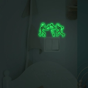 Glow-in-the-dark wall sticker featuring cartoon skeletons around a light switch