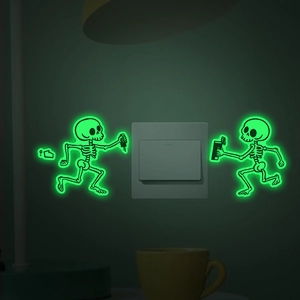 Glow-in-the-dark skeleton wall stickers showing green fluorescent effect near a light switch