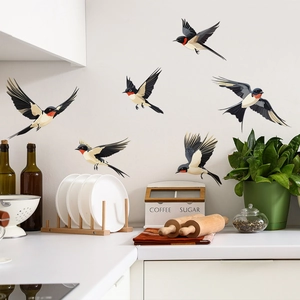 Realistic swallow bird wall stickers set decorating a white kitchen wall near coffee jars