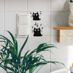 Close-up of cute black cat wall stickers on white tiles with decorative indoor plants
