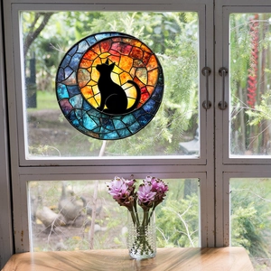Stained glass suncatcher featuring a black cat and moon design on a window frame