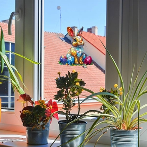 Stained glass style bunny and Easter eggs window decals on glass with sunny garden view