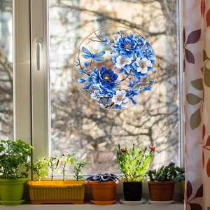 Detail of round floral window film with blue dragonfly and botanical pattern on glass
