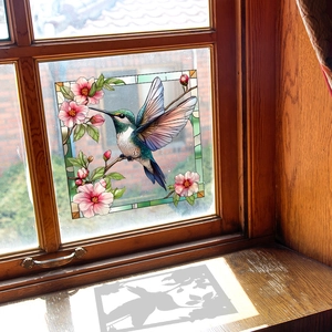 Stained glass hummingbird window cling showing floral patterns with sunlight shadow