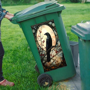 Artistic stained glass style crow and berry sticker on a green outdoor wheelie bin
