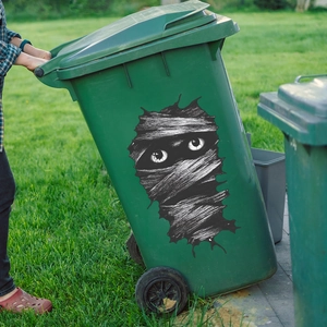 Halloween mummy eyes stickers for outdoor trash bin decoration on a green lawn