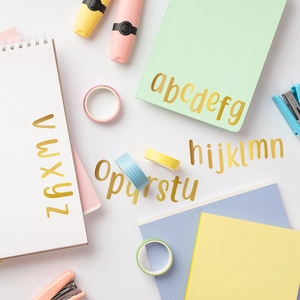 Macro detail of metallic gold letter stickers on a notebook for creative DIY decoration