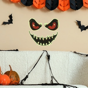 Luminous Halloween wall decal featuring spooky glowing eyes and jagged teeth on a wall