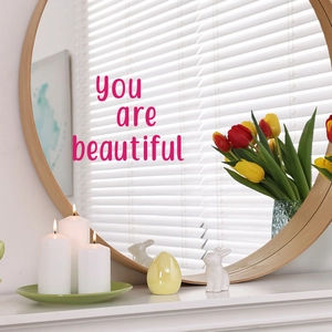 Pink 'you are beautiful' letter stickers for mirror decoration in a warm home setting