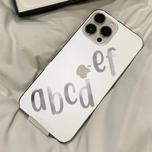 Detail of colorful alphabet letter stickers applied to a sleek silver smartphone back