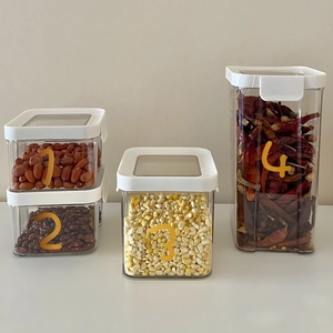 Set of 4 clear plastic food storage canisters with white airtight lids for pantry organization