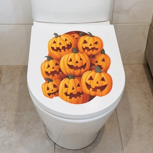 Vibrant Halloween Jack-o'-lantern pumpkin decal stickers on a white toilet lid for bathroom decor