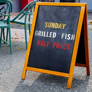 Standing A-frame wooden sidewalk chalkboard sign for restaurant menu and retail promotion