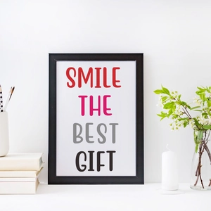 Modern framed poster with SMILE THE BEST GIFT text and minimalist white desk decor