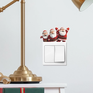 Three cheerful Santa Claus wall stickers decorating a white double light switch panel