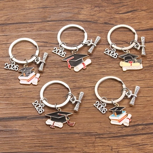2026 Graduation keychain set with black mortarboard and diploma charms on wood surface