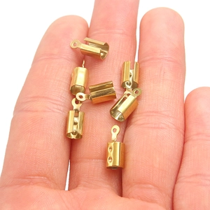 Golden stainless steel cord end caps for jewelry making shown in hand for scale