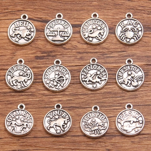 Detailed macro view of retro 12 zodiac constellation alloy pendants on a wooden surface
