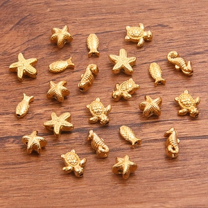 Macro shot of gold vacuum-plated stainless steel sea charms with textured marine animal details