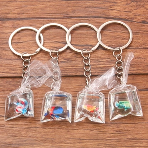 Creative resin fish water bag keychains in four colorful tropical styles on wood background