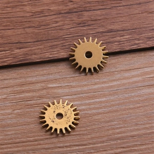 Golden steampunk gear alloy pendant connector for DIY jewelry making on wood background