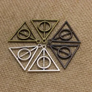 Macro detail of Deathly Hallows dragonfly wing metal pendants in three metallic finishes