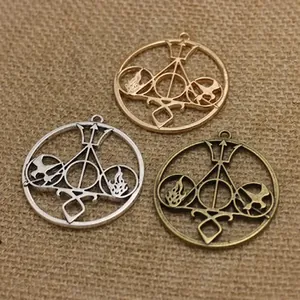 Detail view of round hollow metal pendants with mystical geometric flame and bird patterns