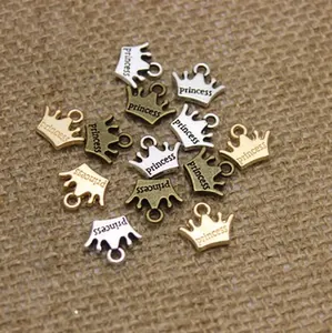 Close-up of crown-shaped DIY pendants with 'princess' engraving in three metal finishes