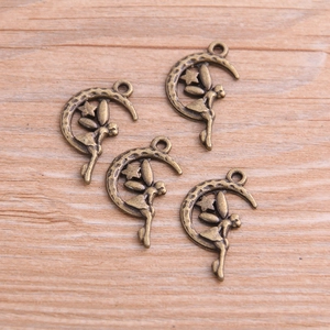 Detailed macro view of four antique bronze angel moon alloy charms on wooden surface
