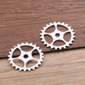 Silver alloy steampunk gear pendants for DIY jewelry making on wooden background