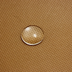 Macro view of a single round clear glass cabochon showing a smooth polished surface