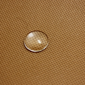 Macro shot of a clear round glass cabochon dome for DIY jewelry making and crafts