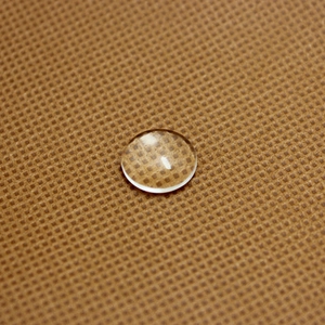 Macro shot of clear water droplet on waterproof brown fabric with fine mesh texture