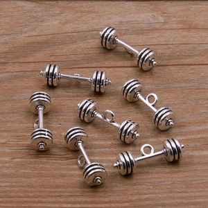 Sept pendentifs d'haltères en argent antique pour bijoux DIY sur un fond en bois