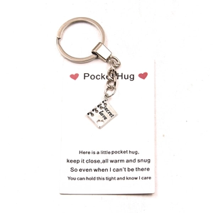 Antique silver Pocket Hug keychain with engraved Secret Love square pendant on gift card