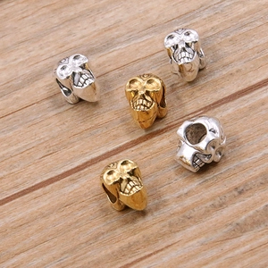 Macro-opname van goud- en zilveren schedelkralen met holle ogen voor DIY gotische sieraden