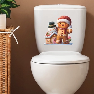 Christmas snowman and gingerbread house toilet decals on a white ceramic tank