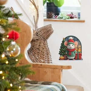 Detailed view of a Christmas mouse hole wall decal with a festive tree and gifts