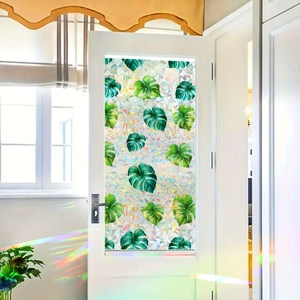 Rainbow monstera leaf window film with colorful light refraction on white door