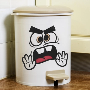 White pedal bin with cartoon face emoji on wood floor and tile background in home