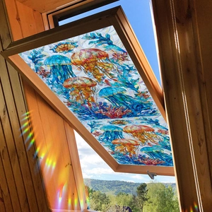 Rainbow jellyfish and coral window film on wooden attic skylight with light refraction