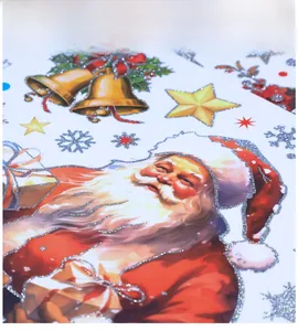 Détail macro d'autocollant de Noël montrant le Père Noël pailleté et une cloche dorée