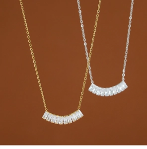 Primer plano de collares de oro y plata con colgantes rectangulares de circonita