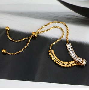 Primer plano de una pulsera tenis dorada ajustable con piedras de circonita rectangulares