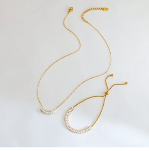 Vista de detalle del conjunto de collar y pulsera dorados con circonitas rectangulares